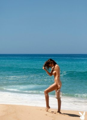 Мокрая сексуальная девушка топлес на пляже