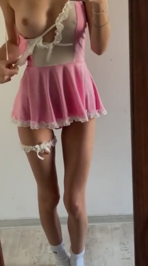 Шаловливая стерва в коротком платье красуется своей обнаженной грудью перед зеркалом