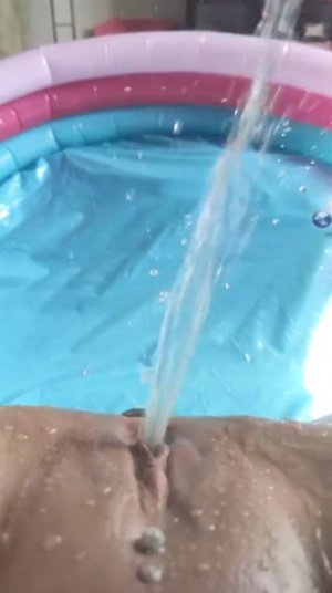 Извращенка мастурбирует бритую киску и сквиртует прямо в надувной бассейн